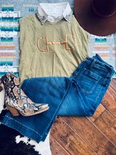 Load image into Gallery viewer, Green sleeveless top with horse logo, blue jeans, brown hat, and patterned boot on a wooden floor.
